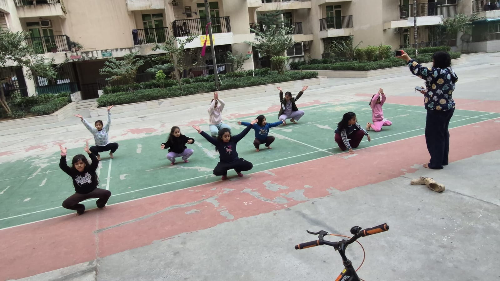 Pooja guiding children during an outdoor dance practice